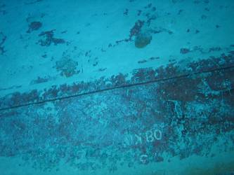 Large section of hull in debris field with "08KO" painted on plating